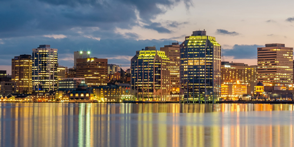 Panoramic Skyline of Halifax City illuminated at night reflecting in the water of Halifax harbour.